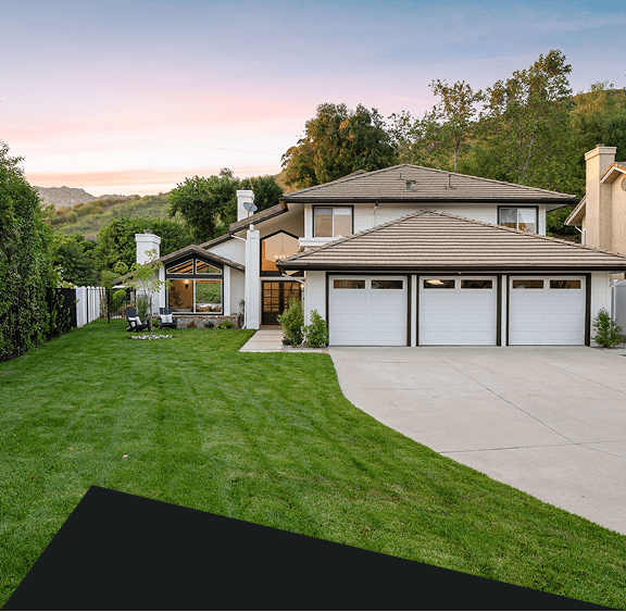 Modern house with large lawn and driveway.